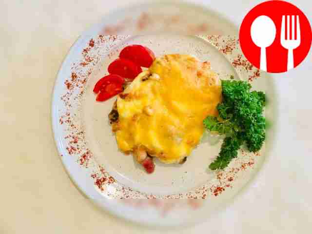 Pork topped with cheese and vegetables