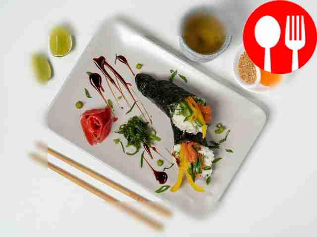 Place the temaki sushi on a black rectangular...