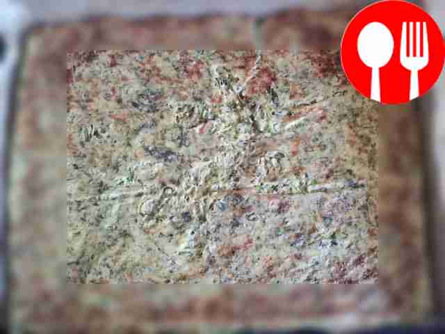 Spread the prepared and cooled zucchini crust...