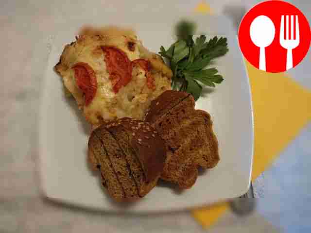 Meat and potatoes baked under a cheese crust with tomatoes