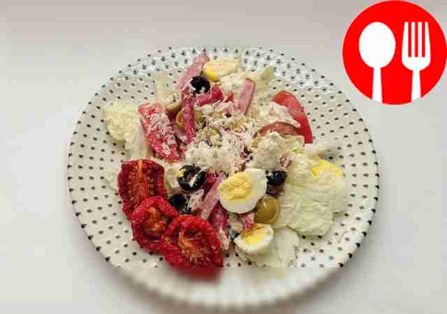 Variegated salad with sausage, olives and quail eggs