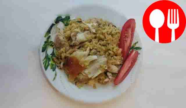 Rice with chicken thighs in a frying pan with coconut milk