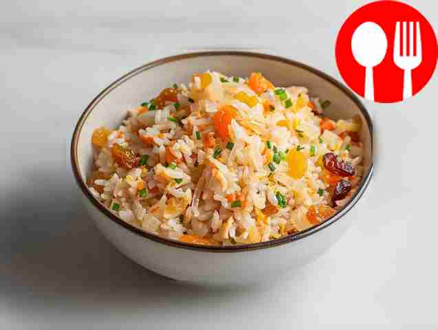 Spicy rice with dried apricots and raisins in a cauldron