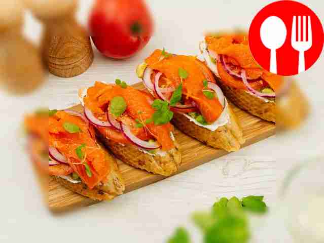Sandwich with salmon, avocado, tomatoes and onions