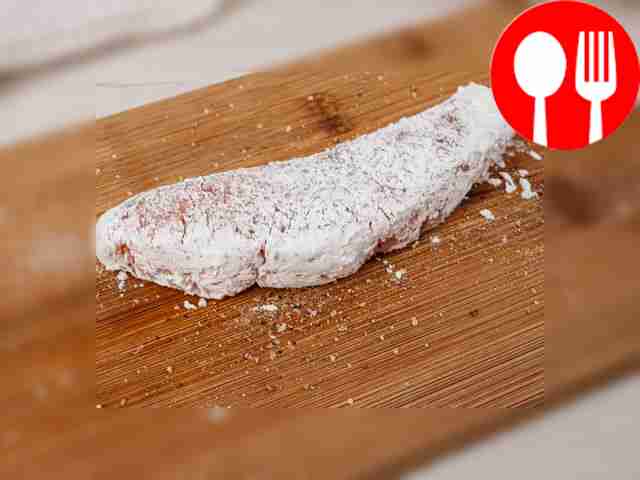 Обваляйте ломтики семги в крахмальном порошке.