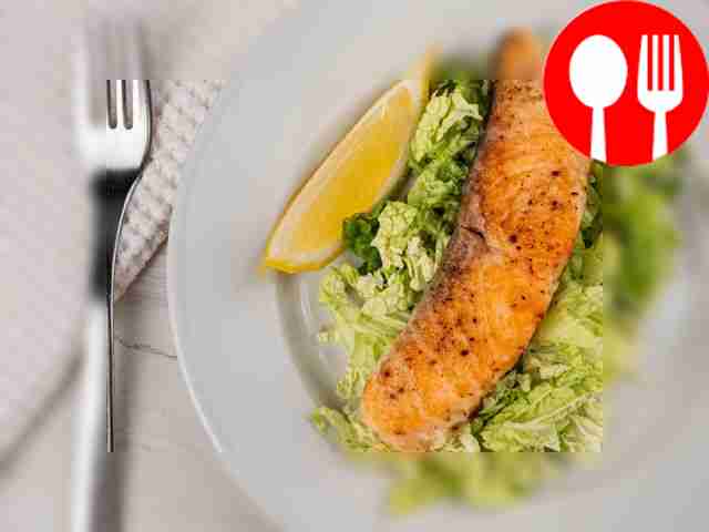 Подавайте рыбу с ломтиком лимона и свежими...