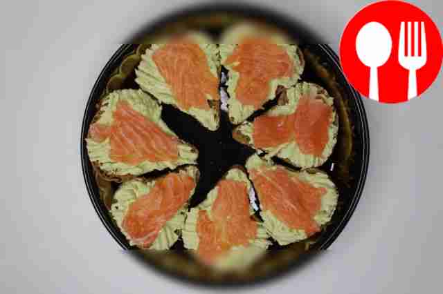 Spread cheese and avocado on slices of black...