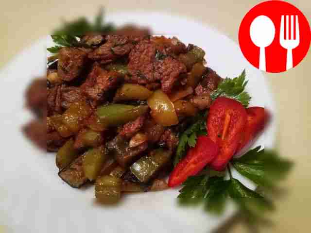 Pork stewed with vegetables and herbs in a frying pan