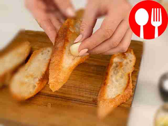 Rub the bread slices with a clove of garlic.