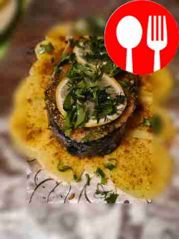 Trout steak with garnish on a charcoal grill