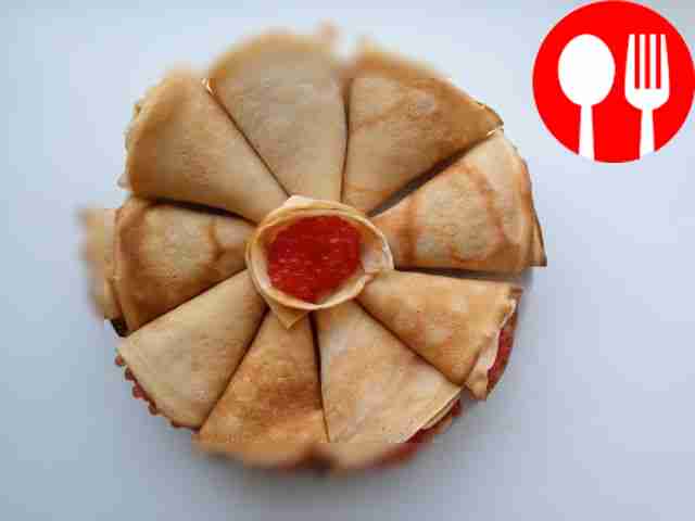 Разложите блины по тарелке и посыпьте их петрушкой.