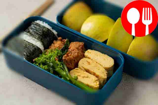 Japanese bento with onigiri, omelette and chicken strips