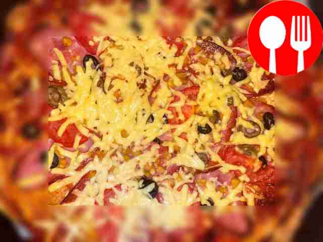 Украсьте пиццу свежей зеленью и овощами.