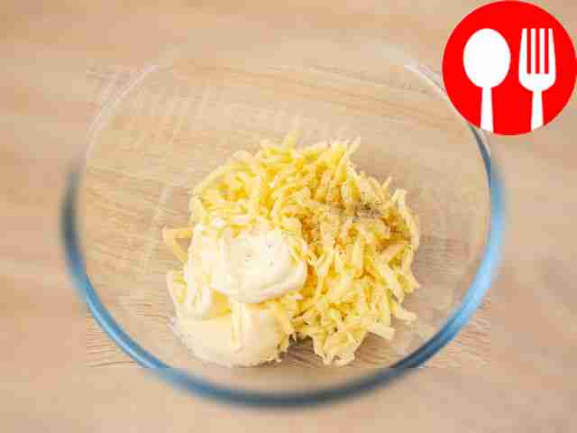 В глубокой миске соедините натертый сыр, две...