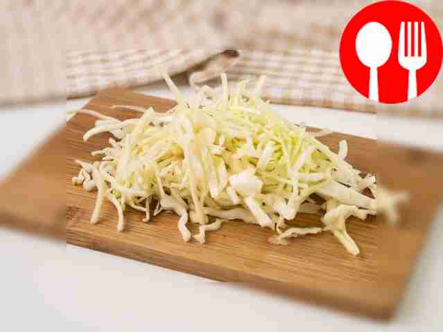 Shred the cabbage on a cutting board.