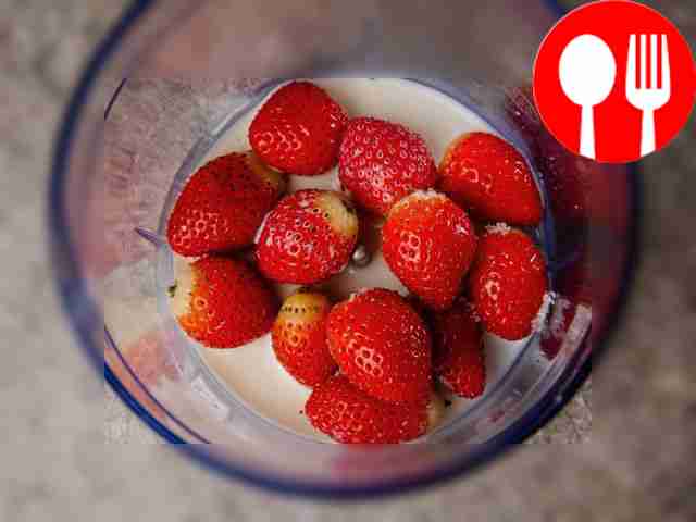 Поместите клубнику и сахар в чашу блендера,...