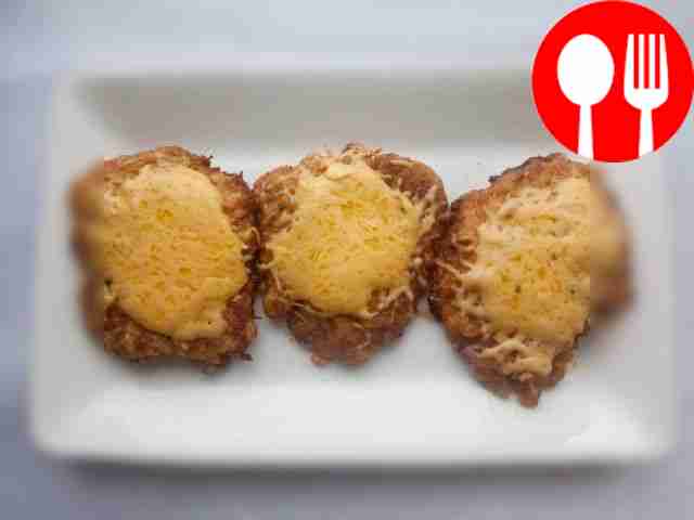 Homemade pork chops with cheese in a frying pan