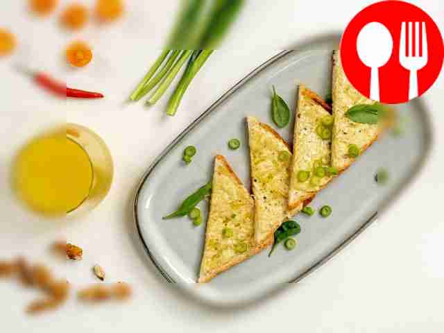 Garnish buttered toast with spinach leaves.