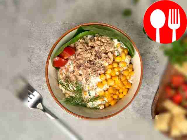 Serve fish salad with corn to the table in...