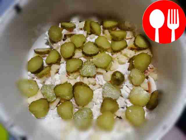 Нарежьте огурцы и уложите их следующим слоем,...