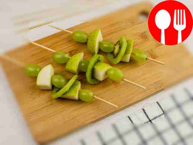 Place apple slices, kiwi slices and grapes on...