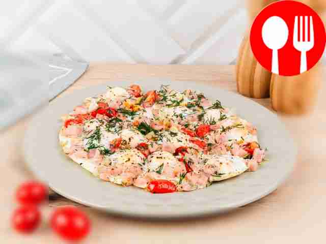 American scrambled eggs with ham and cherry tomatoes