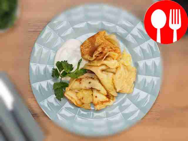 Serve cheese pancakes with sour cream, garnish...