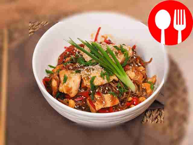 Wok noodles in sauce with chicken, cashew nuts and ginger root