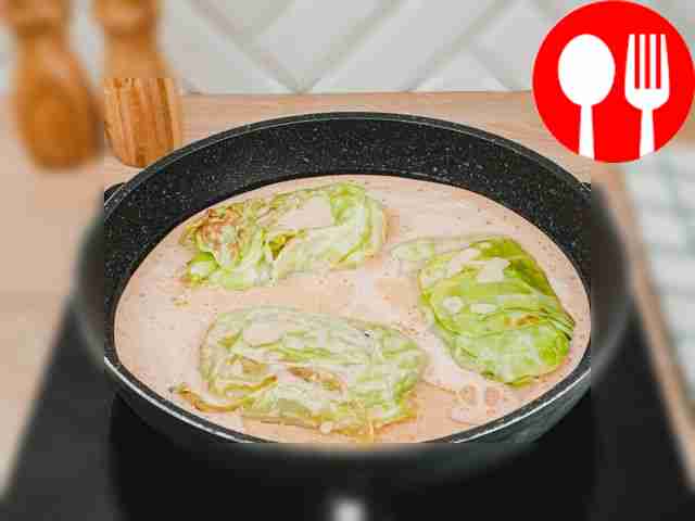 Полейте голубцы соусом из сметаны и томатов.