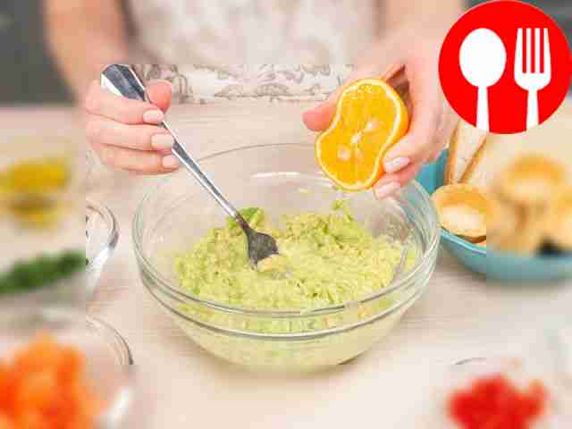 Start making guacamole. Scoop out the avocado...