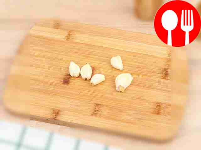 Crush the garlic with the flat side of the knife.