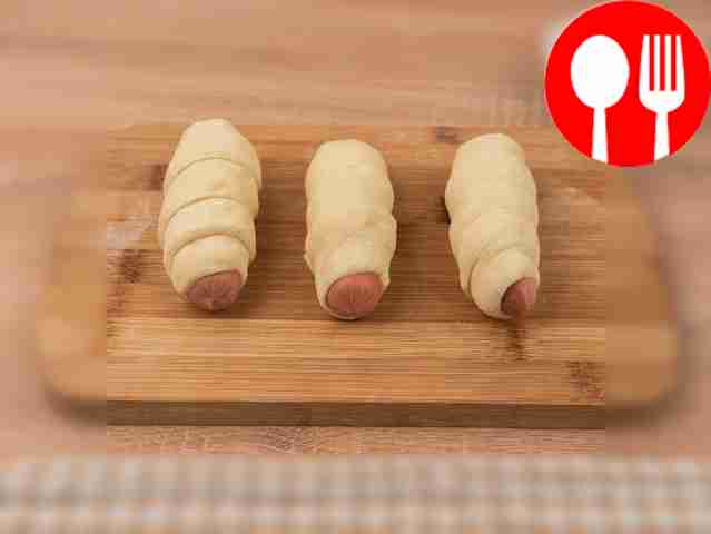 Wrap a strip of dough around each sausage.