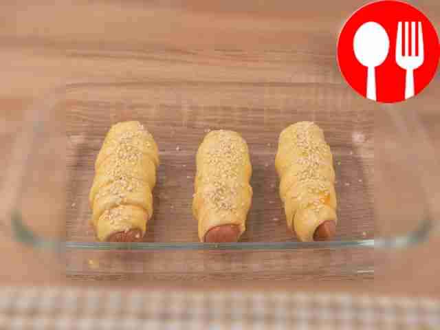 Brush the sausages with egg yolk and sprinkle...