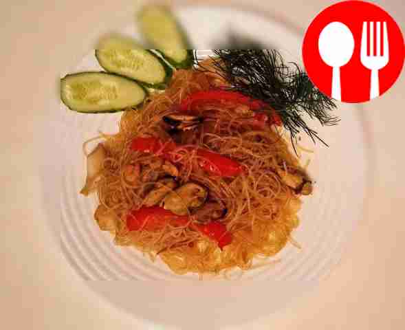 Funchoza with seafood and vegetables in a wok pan