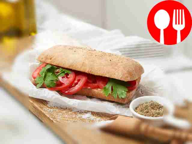 Sandwich with hummus, tomatoes and herbs
